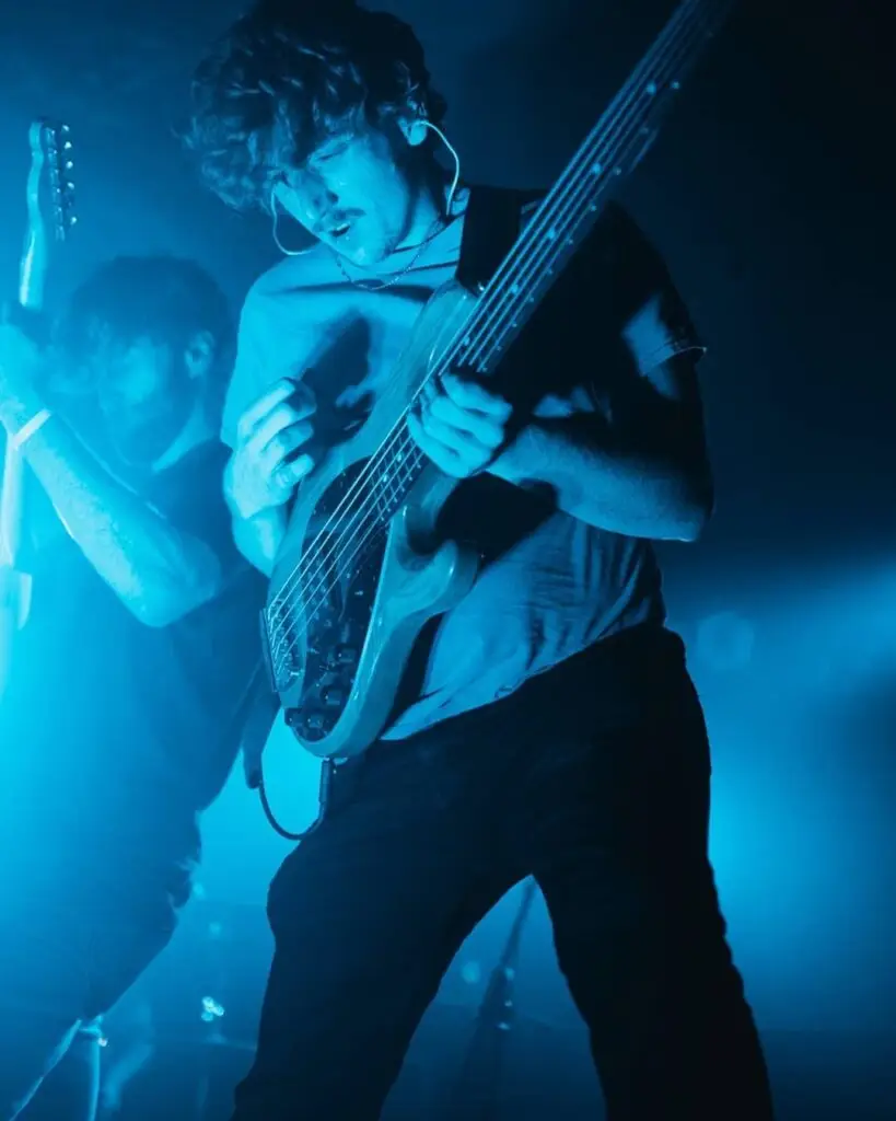 Hayden Playing Bass on stage with vibrant blue lighting